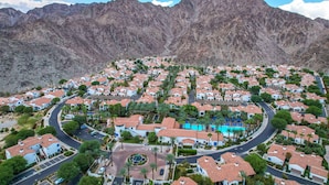 Zona residencial con casas, una rotonda central y montañas al fondo.