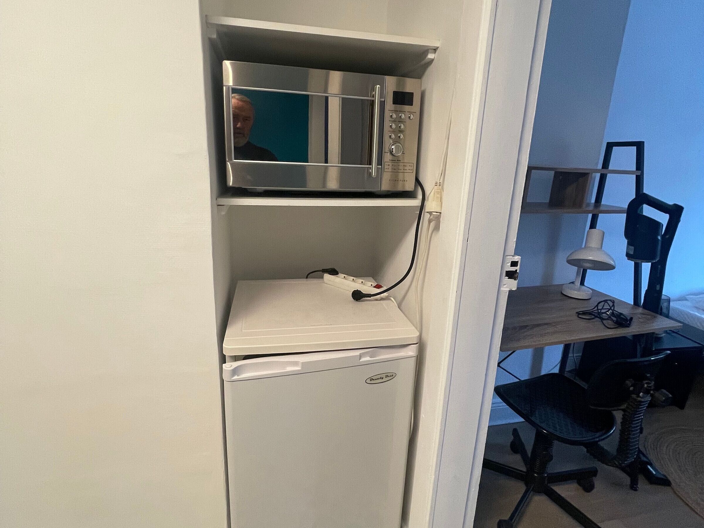 Une petite cuisine équipée d’un four à micro-ondes et d’un mini-réfrigérateur.