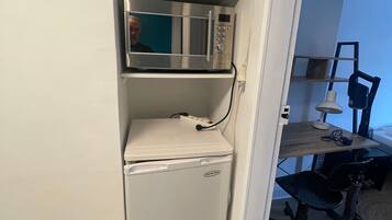 Une petite cuisine équipée d’un four à micro-ondes et d’un mini-réfrigérateur.