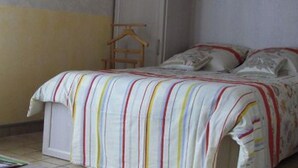 A bedroom with a bed, a wardrobe, and a wooden hanger rack. - Cozy studio in Nancy, near center, wifi included (Nancy)