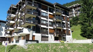 A multi-story hotel with balconies, stone facade, and a sign reading 'Le Wapiti'. - 3* Apartment near slopes and shops, Wi-Fi (La Clusaz)