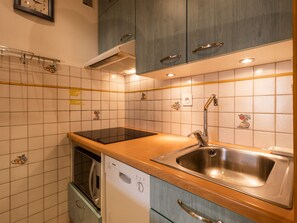 Eine Küche mit Geschirrspüler, Spüle und Schränken.
