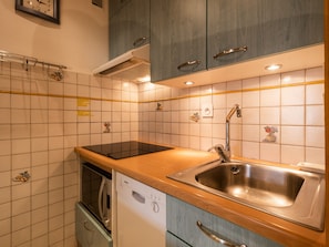 A kitchen with a dishwasher, a sink, and cabinets. - 3* Apartment near slopes and shops, Wi-Fi (La Clusaz)