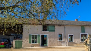 A two-story building with a stone facade, green shutters, and a statue in the foreground. - Family cottage with shared pool, terrace, and WiFi (Ségry)
