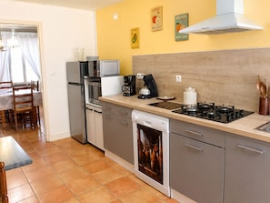 A modern kitchen with a dishwasher, stove, microwave, and coffee maker.