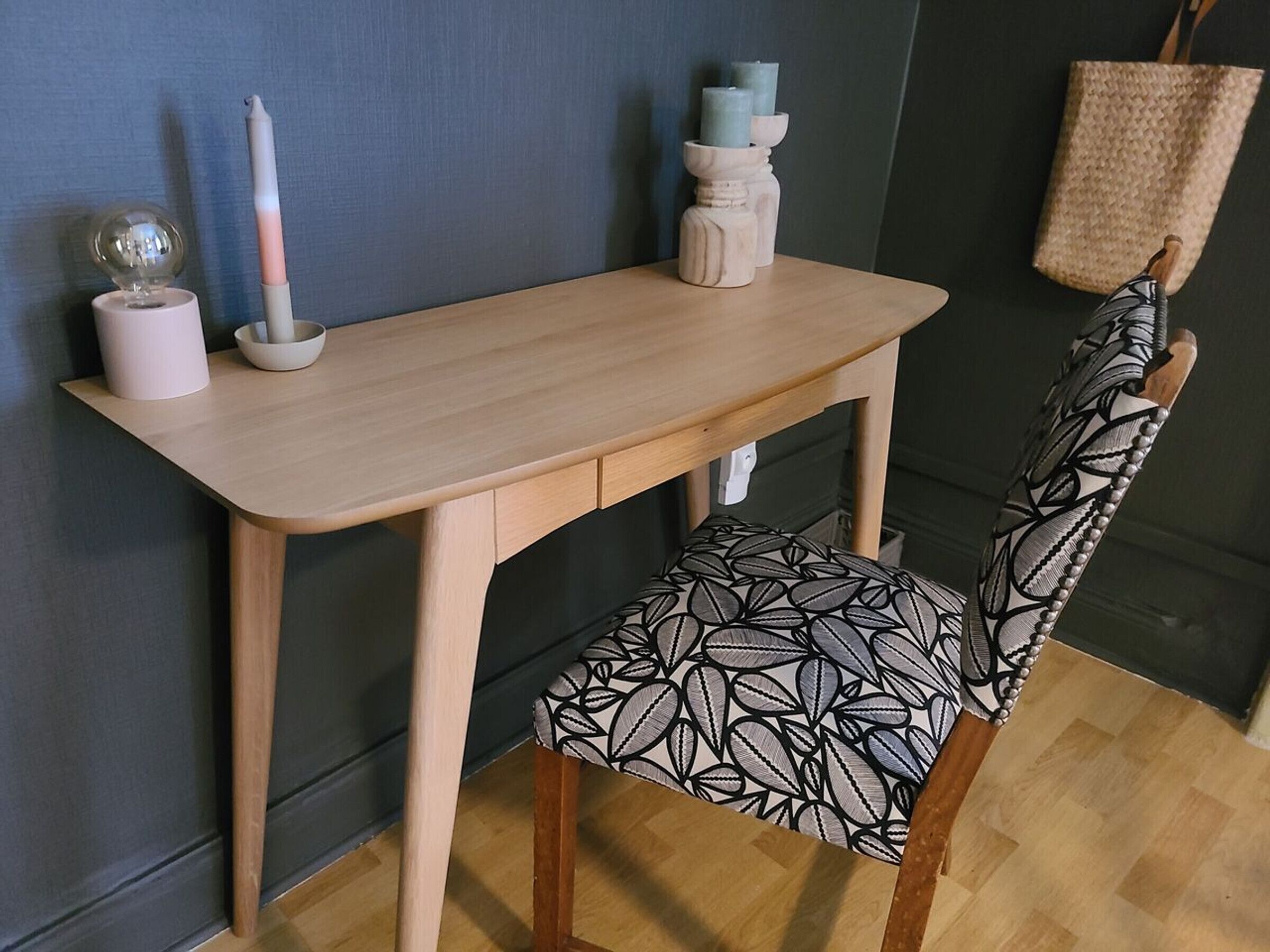 Een houten eettafel met een stoel met een zwart-wit bladmotief.