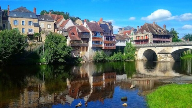 A river with a stone bridge, buildings with balconies, and a clear blue sky. - Cozy townhouse with garden near Argenton-sur-Creuse (Saint-Marcel)