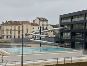 Un edificio moderno con piscina y una estructura de tobogán de agua única.