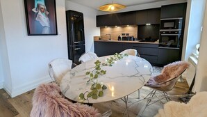 A modern kitchen with dark cabinetry, a built-in oven, and a microwave. - Renovated apartment with garden, parking, and WiFi in Gérardmer (Gérardmer)