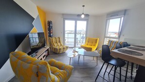 Un salon moderne avec un canapé, un fauteuil et un coin repas.