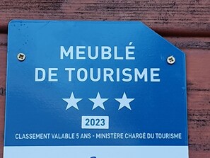 A sign with 'MEUBLÉ DE TOURISME' and '2023' indicating a tourism-related service or award. - Family chalet Vosges with foosball and pets allowed (Ventron)