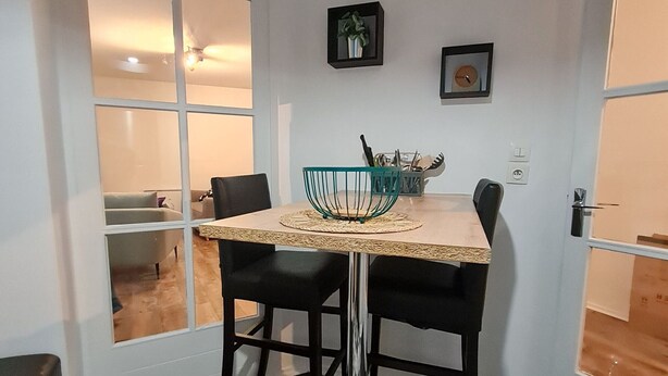 A dining area with a table, chairs, and a decorative bowl. - Central and quiet apartment, near Stanislas Square (Nancy)
