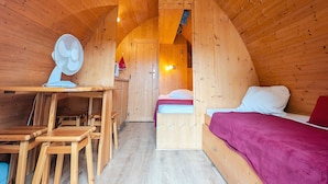 Un interior de madera con una cama, un escritorio y una silla.