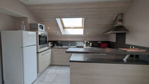A modern kitchen with a built-in oven, microwave, and a large window above the sink.