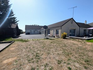 Zona residencial con casas, un aro de baloncesto y cielo despejado.