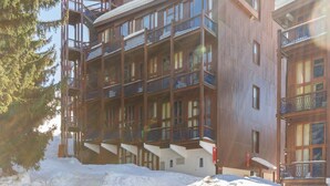 A multi-story hotel with balconies and a ski lift visible in the background. - Calm duplex near slopes with balcony (Les Arcs 1800)