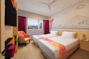 Une chambre d’hôtel avec deux lits, une télévision, un bureau et une fenêtre donnant sur la ville.
