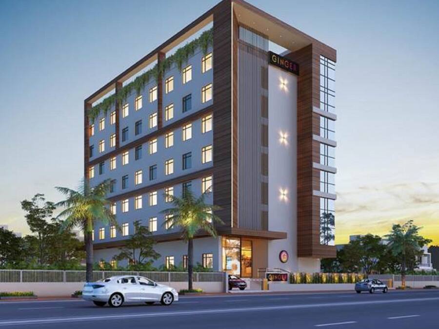 A multi-story hotel with a modern design, featuring a prominent 'GINGER' sign on the facade.
