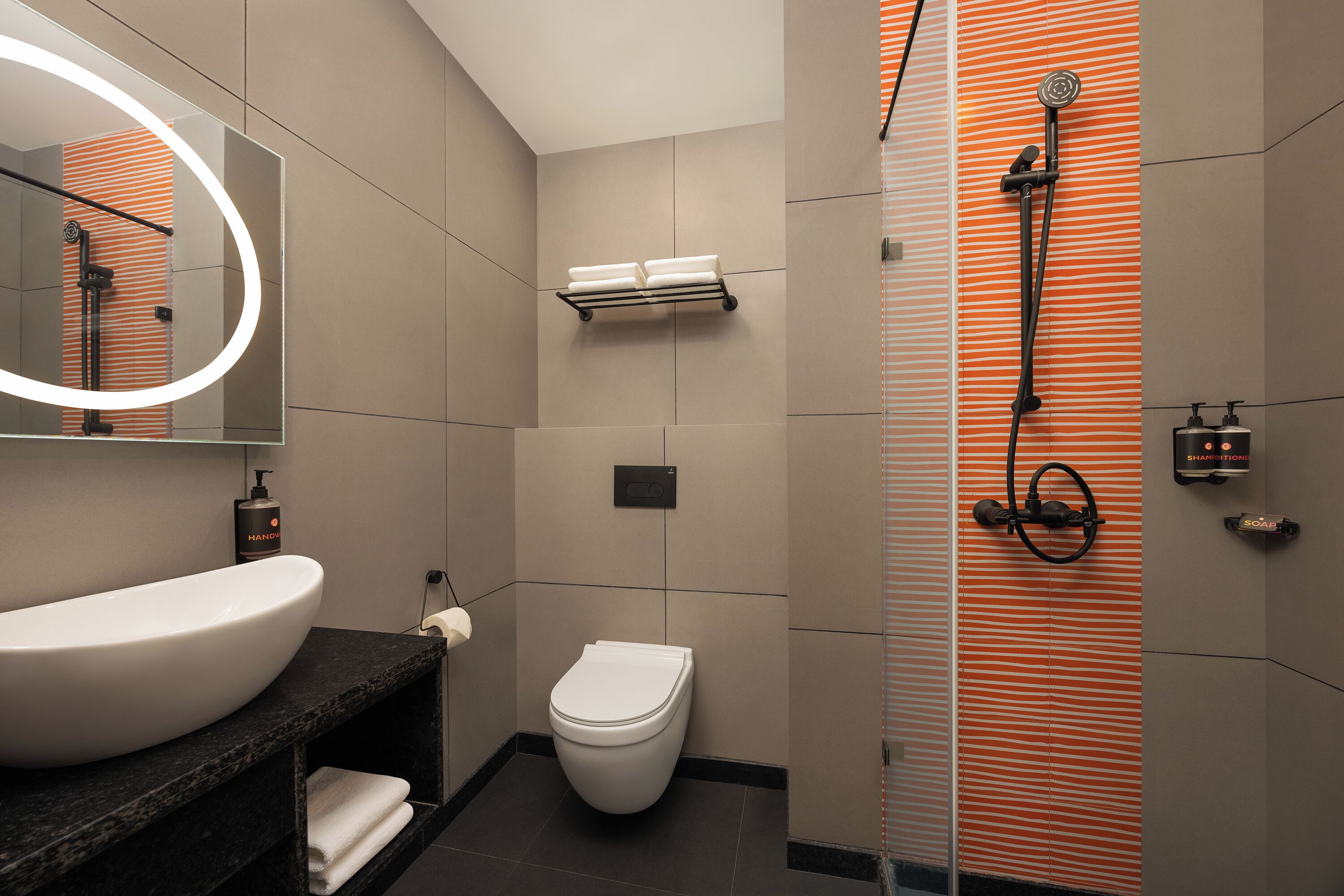 A modern bathroom with a large sink, toilet, and shower.