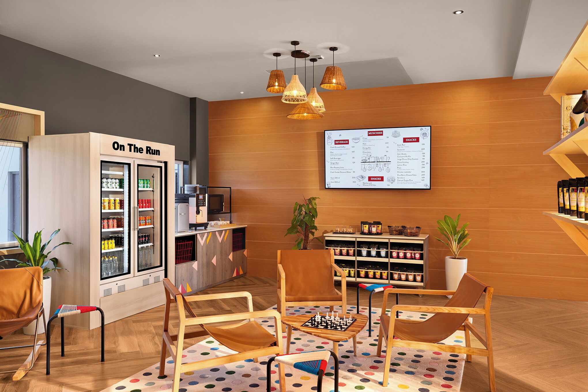 Un moderno salón de estar con una mesa de ajedrez, asientos cómodos, un refrigerador para bebidas y un panel con la carta.