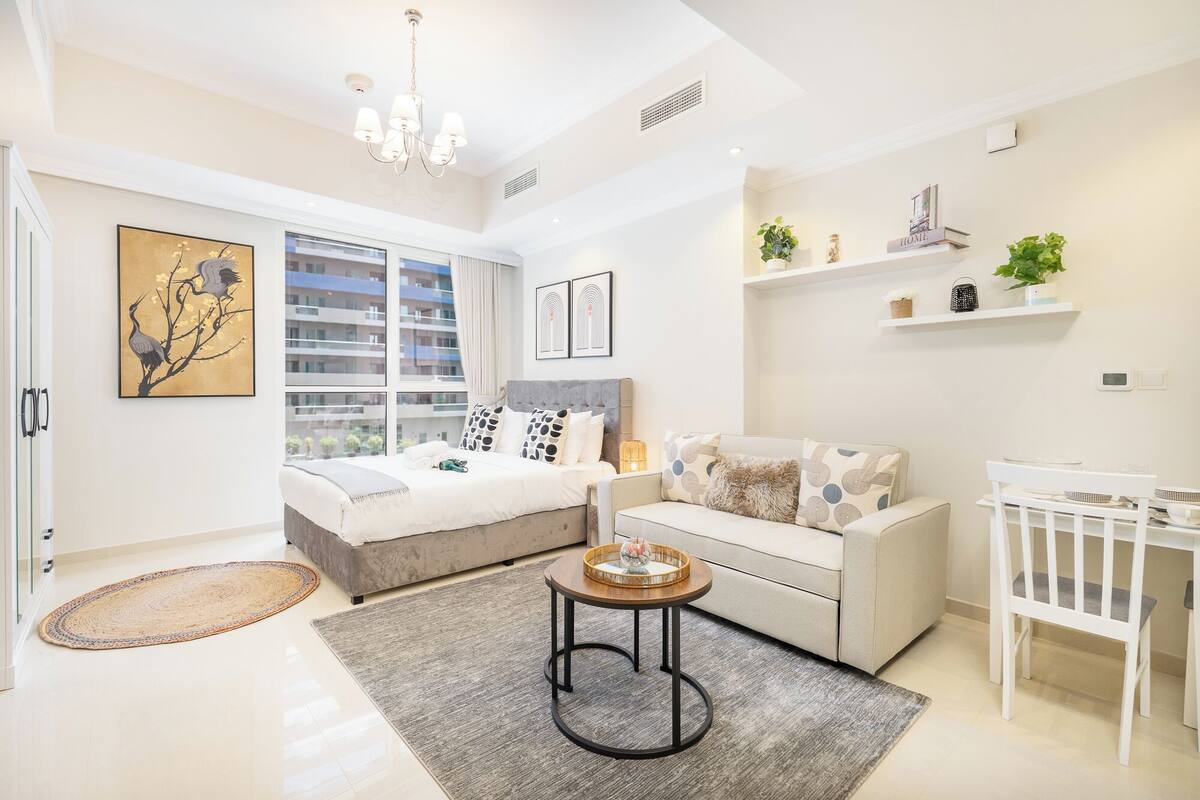 Une chambre à coucher moderne avec un lit, un canapé, une petite table et un berceau.
