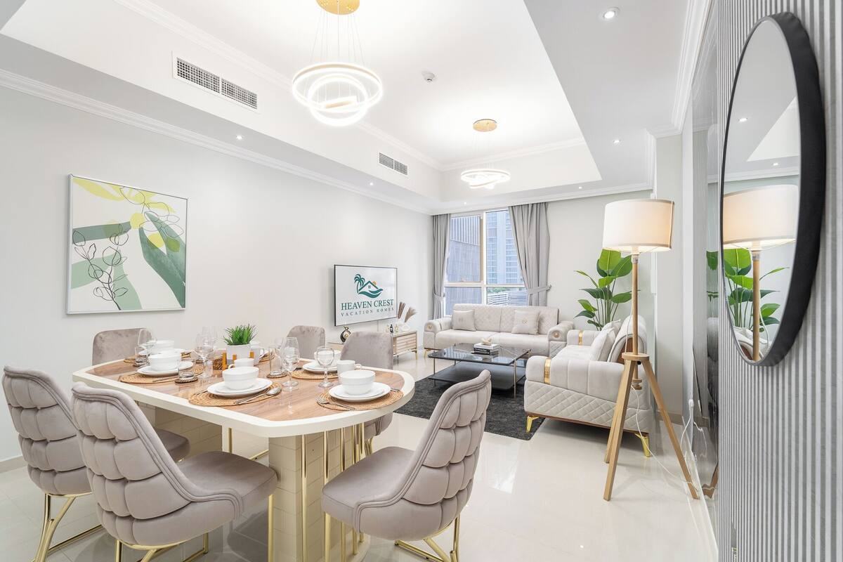 Une chambre d’hôtel moderne dotée d’un coin repas, d’un canapé et d’un grand miroir.