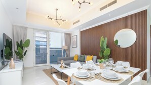 Un comedor moderno con una mesa blanca para cuatro, un espejo grande y un muro de acento de madera.