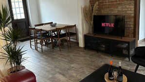 Ein Wohnzimmer mit Esstisch, Stühlen, einem Fernseher und einem Kamin.