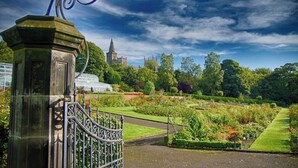 A gated entrance to a park with manicured lawns and a distant church spire. - Dunfermline GF flat, 5 mins to Train St. & High St

 (Dunfermline)