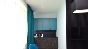 A modern kitchen with dark marble countertops, teal cabinets, and a black backsplash. - stay with legends (Hamburg)