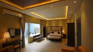 A modern hotel room with a bed, bedside table, lamp, TV, and a view of the outdoors.