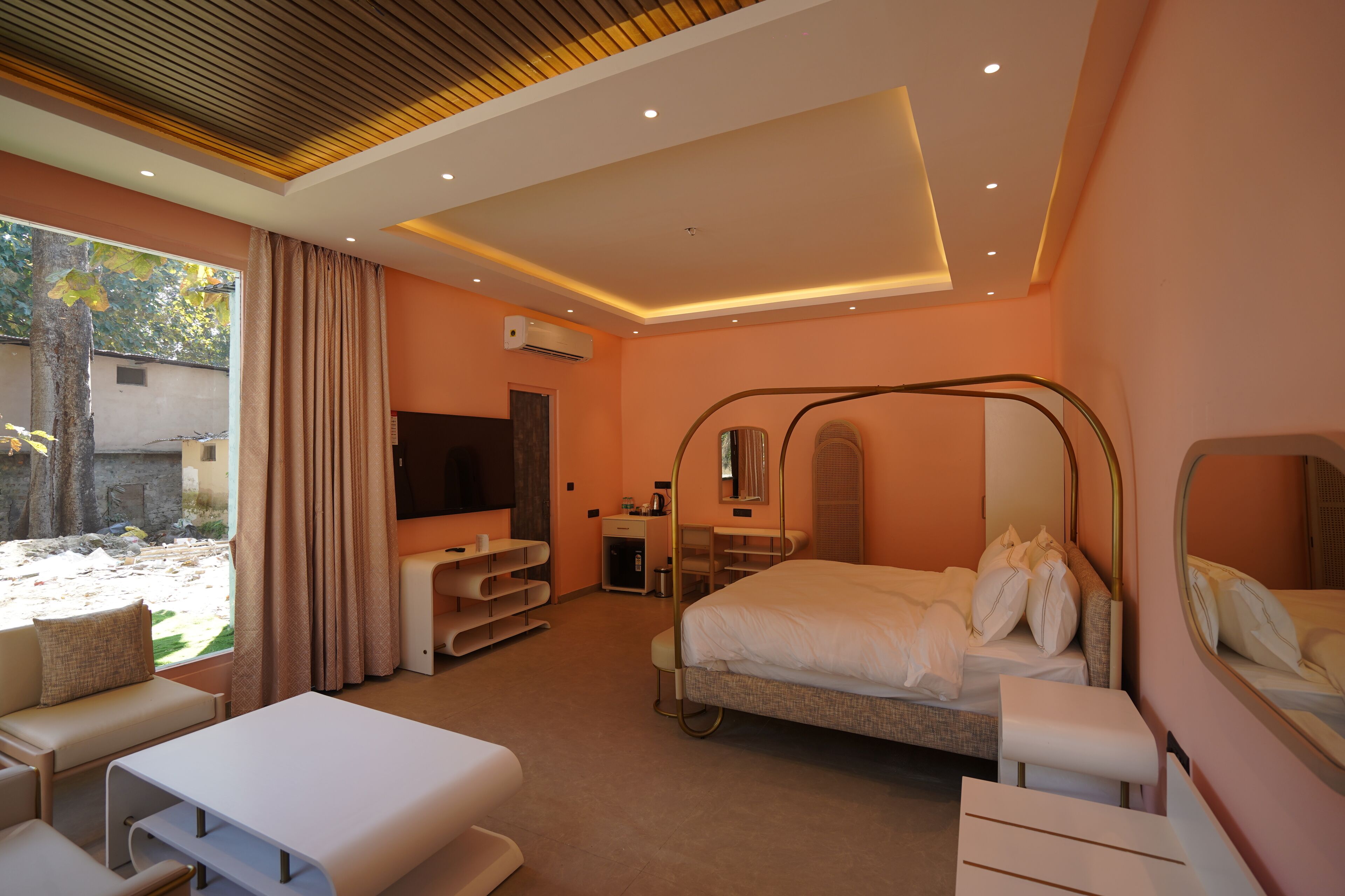 Una habitación de hotel moderna con cama, escritorio, televisor y un amplio ventanal.