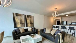 A modern living room with a sofa, coffee table, and artwork on the wall. - Gold Tower - Bright 3 BDR Apt in Costa del Este (Panama City)