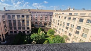 A multi-story building with a courtyard featuring green landscaping and a central fountain. - "BlueSky" air-conditioning-wi-fi garage- 5m from town center.  (Aix-en-Provence)