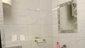 Un baño con inodoro, lavamanos y ducha.