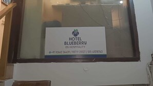 Zona de recepción de un hotel con un cartel que dice HOTEL BLUEBERRY DS HOSPITALITY.