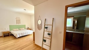 Un dormitorio con cama, mesita de noche y un colgador de macramé en la pared.