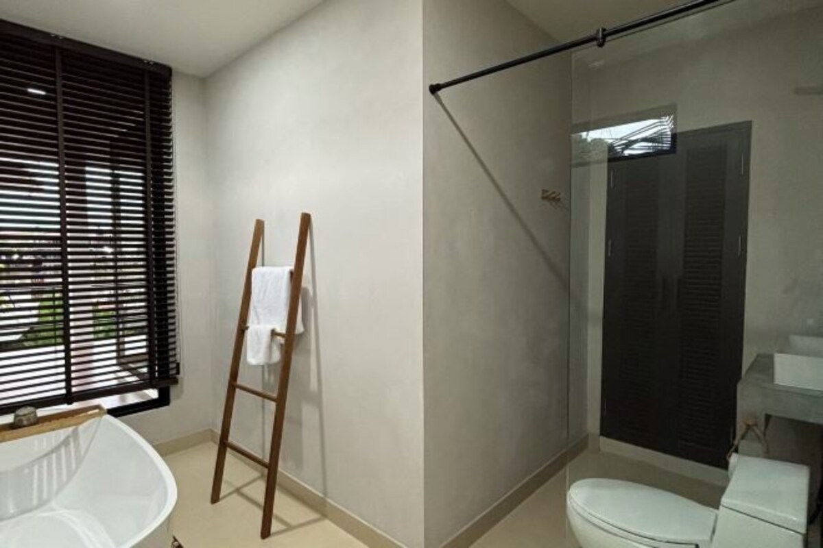 Un baño moderno con bañera, inodoro y cabina de ducha de vidrio.