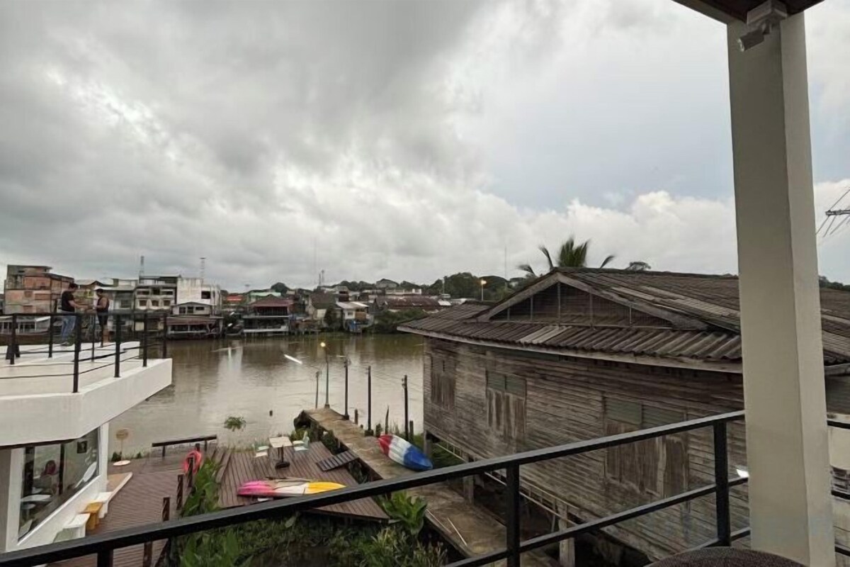 Vista para a frente marítima com edifícios, um cais e um céu nublado.