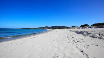 On the beach, white sand, sun-loungers, beach umbrellas