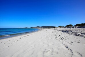 På stranden, vit sandstrand, solstolar och parasoller