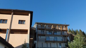 A multi-story building with balconies and a clear blue sky. - Complex Veverita  (Novaci)