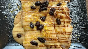 A dessert on a black plate with a wooden table background. - Complex Veverita  (Novaci)