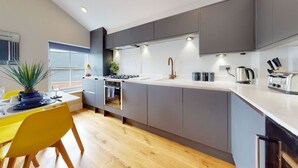 A modern kitchen with grey cabinets, a white countertop, and a built-in oven.