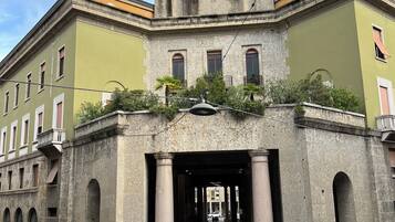 Un edificio histórico con una torre de reloj, grandes columnas y una entrada portonada.