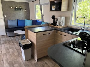 A compact kitchen with a built-in island, a microwave, a coffee maker, and a sink.