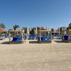 Na praia, espreguiçadeiras, guarda-sóis, toalhas de praia