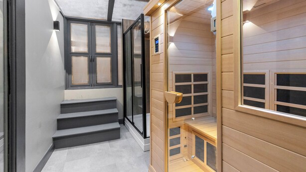 A modern interior with a staircase leading to a wooden mezzanine.