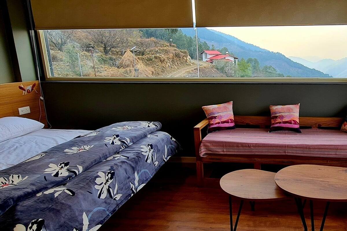 Una habitación acogedora con una cama, un sofá y dos mesitas.