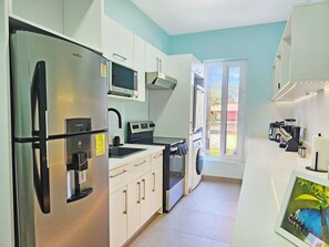 A modern kitchen with stainless steel appliances, a microwave, and a coffee maker.